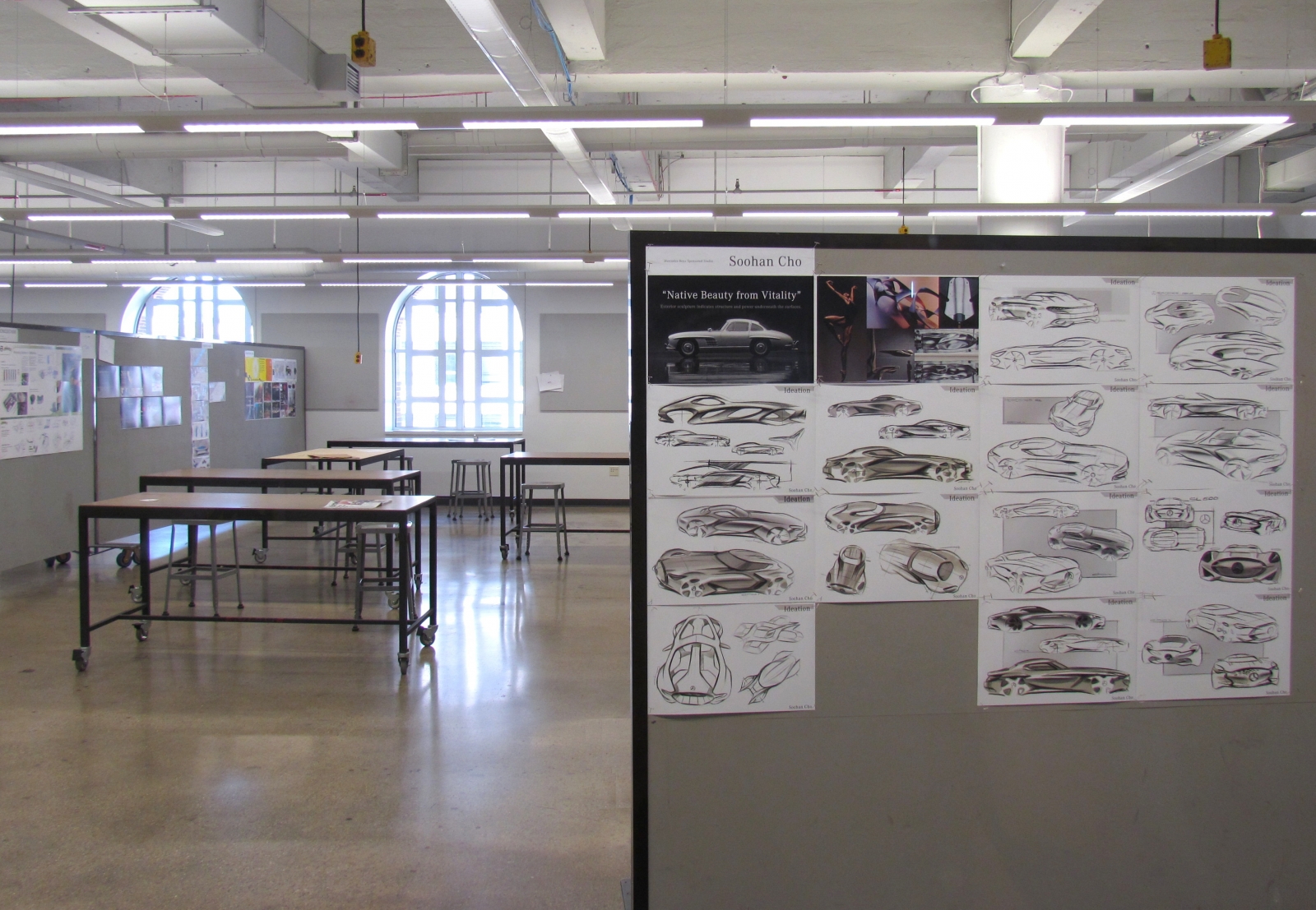 an exhibition in detroit with drawings of cars pinned to a wall